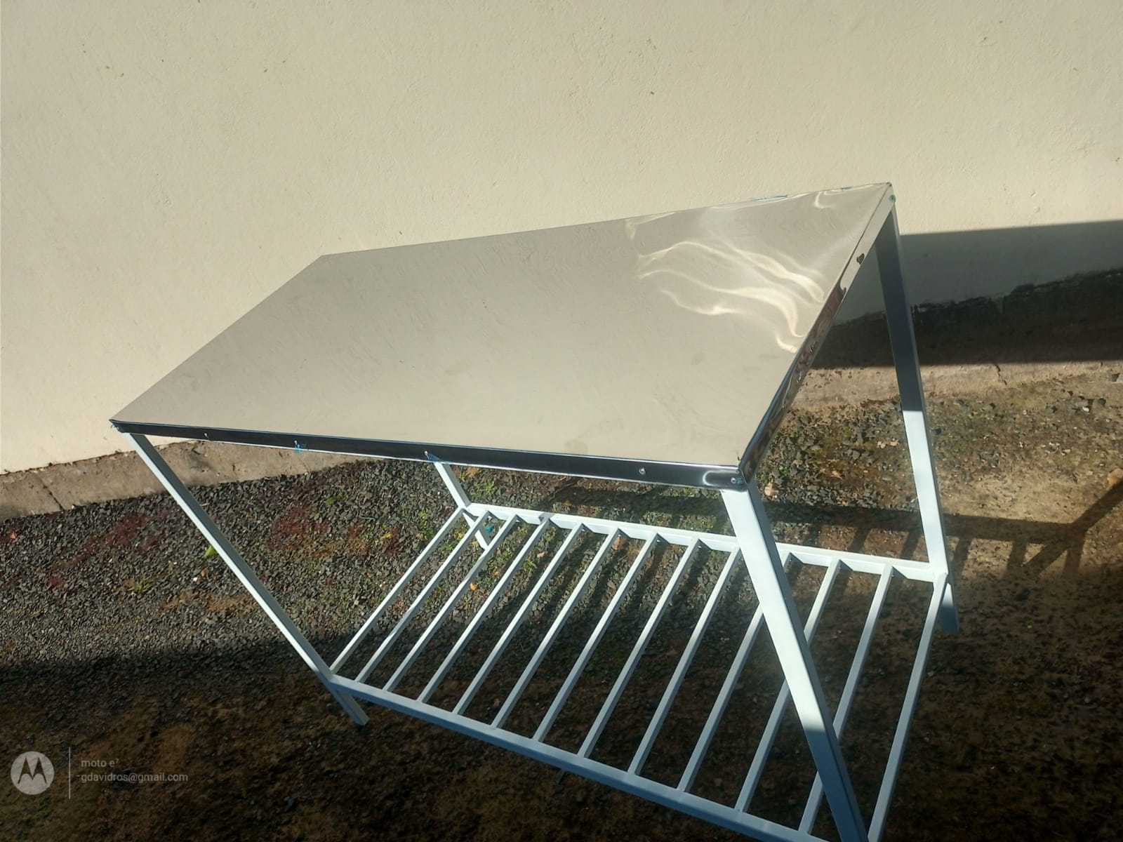 Mesa em inox com estrutura branca e prateleira aramada